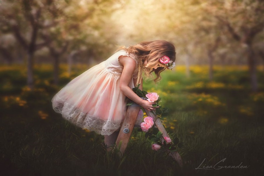 A beautiful girl climbing the ladder before a spring backdrop