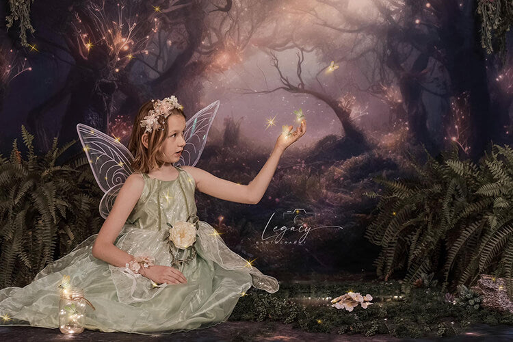 girl in green dress sitting in front of a forest backdrop