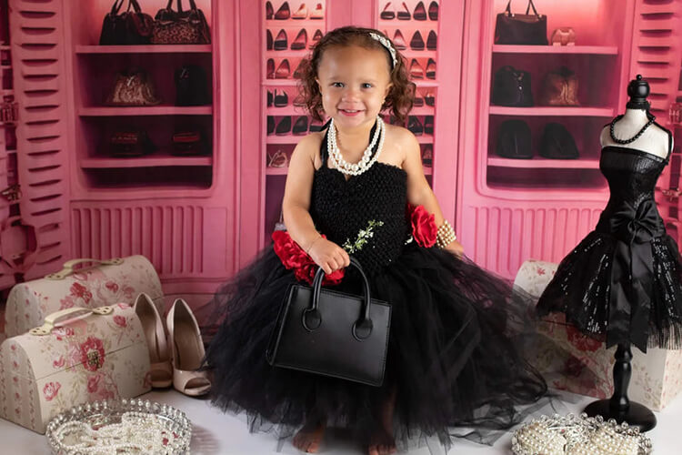 girl standing in front of a pink closet backdrop