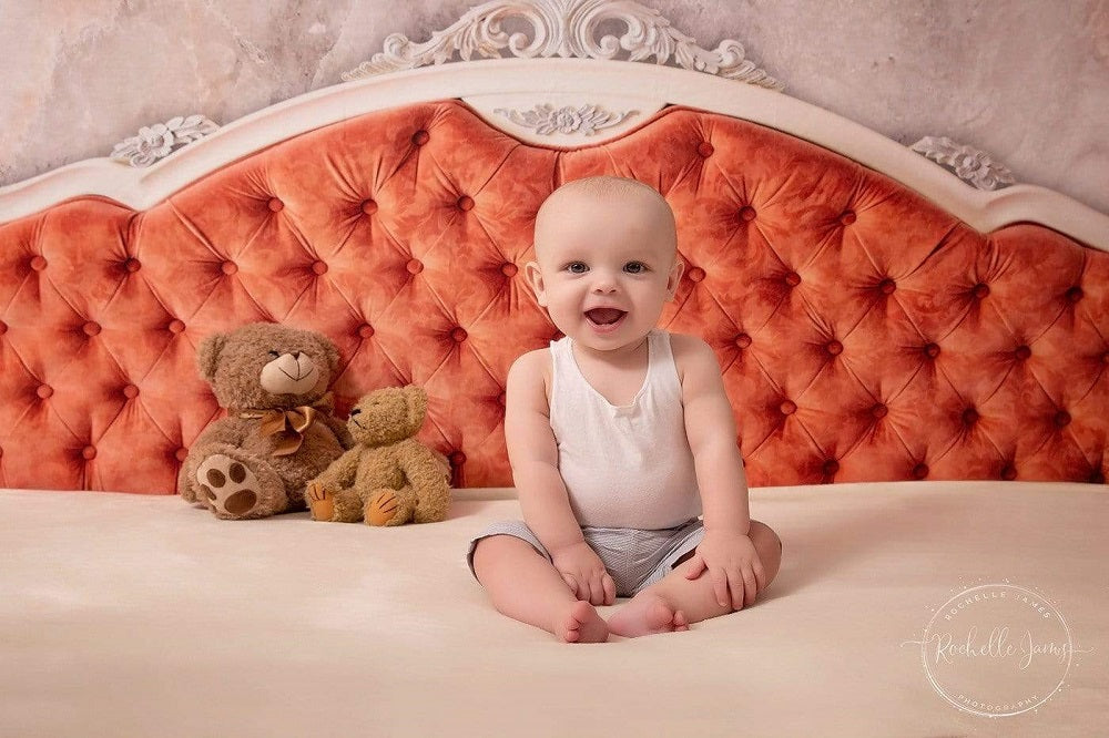 baby sitting on the bed headboard backdrop