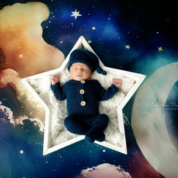 Baby lying in a five-pointed star prop on a blue night starry sky backdrop