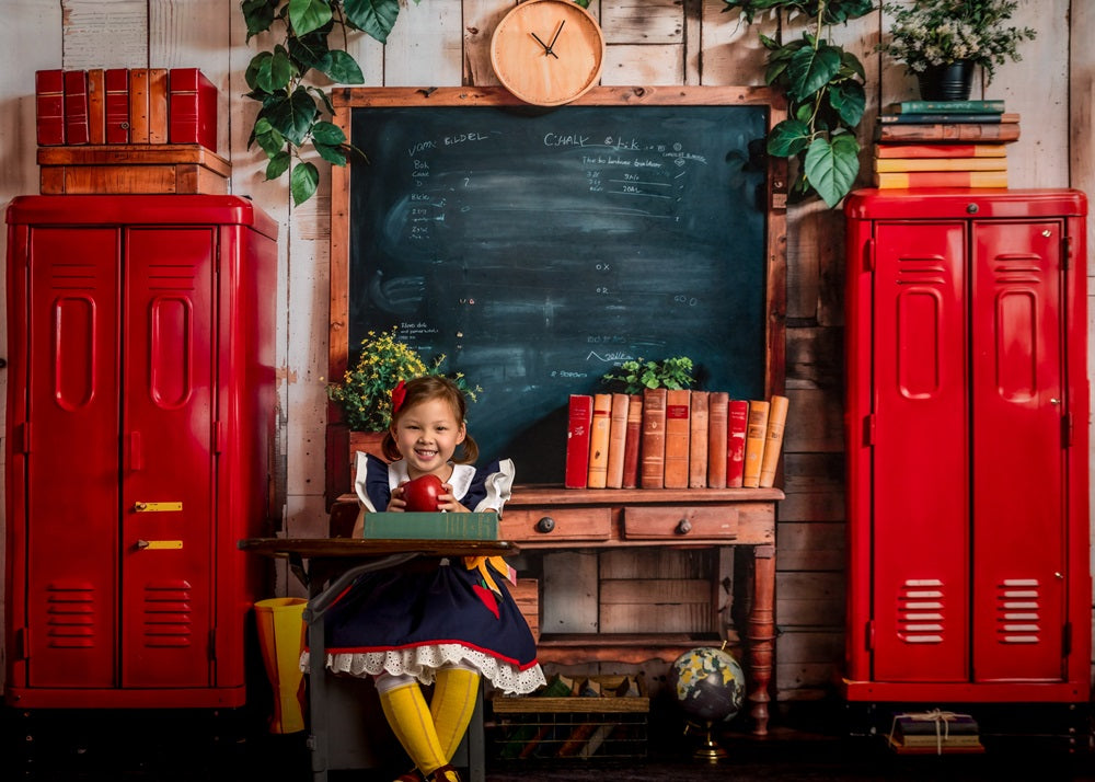 A girl sitting in front of red locker back to school backdrop