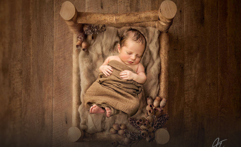 baby lying on the bed prop on the brown rubber floor mat